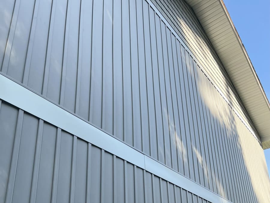 Grey board-and-batten siding with a downspout